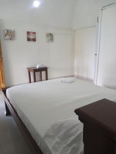 a large white bed in a room with a table at Hotel EL PALMAR TOURS in Arboletes