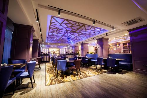 a restaurant with tables and chairs and a bar at Absolute Hotel in Astana