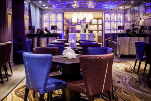 a dining room with blue chairs and a table at Absolute Hotel in Astana