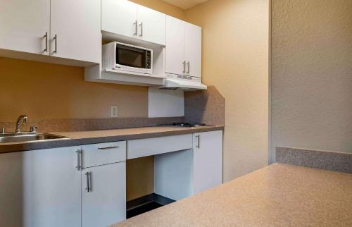 a kitchen with white cabinets and a microwave at Extended Stay America Suites - Detroit - Ann Arbor - Briarwood Mall in Ann Arbor