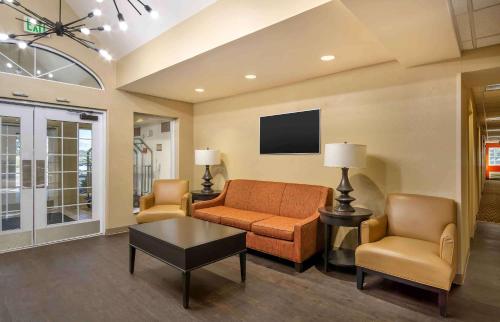 a living room with a couch and two chairs and a tv at Extended Stay America Suites - Charleston - Airport in Charleston