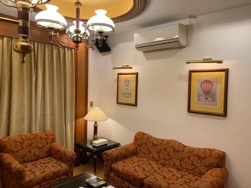 a living room with a couch and a chair at Hotel Karakonosato 唐比の里 in Isahaya