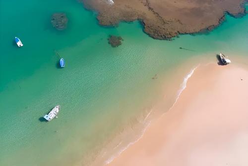 an overhead view of a beach with boats in the water at Lindo Apto Águas de Guarajuba in Guarajuba