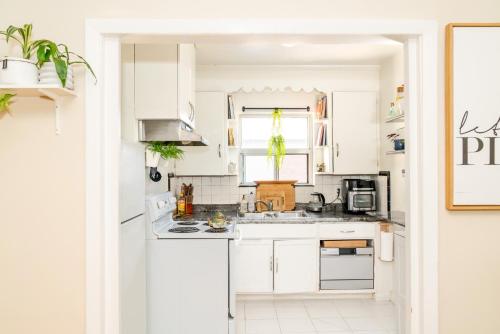 a white kitchen with white cabinets and a sink at Room in cozy house close to Lawrence Ave, WiFi, parking in Toronto