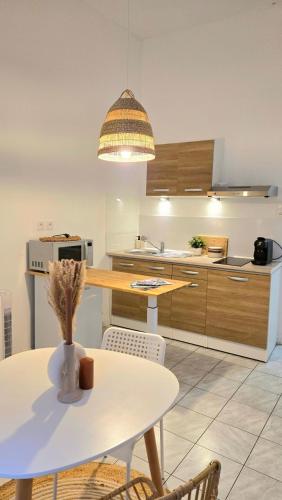 une cuisine avec une table blanche et une table blanche dans l'établissement Joli Cocon Avignon intramuros, à Avignon