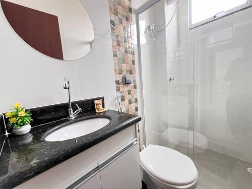 a bathroom with a toilet and a sink and a shower at Apt no Santa Mônica próximo ao Pátio Sabiá, UFU in Uberlândia