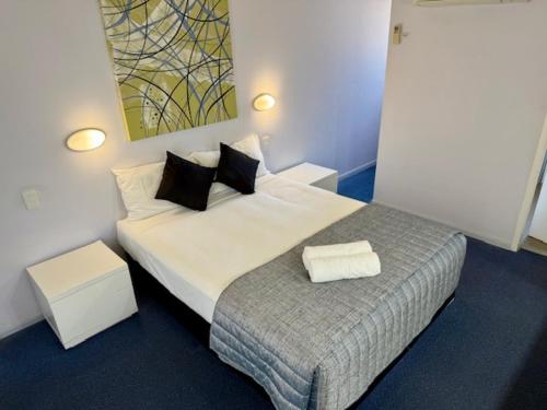 a bedroom with a bed with two towels on it at Cleveland Bay Air Motel in Cleveland