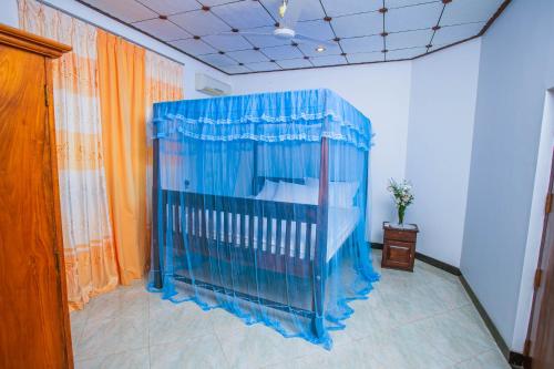 a blue crib in the corner of a room at Chilaw D&D Holiday Home in Welihena