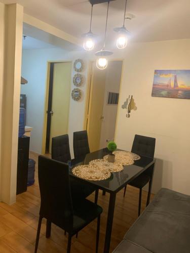 ein Esszimmer mit einem schwarzen Tisch und Stühlen in der Unterkunft Seawind Condominiums Tower 1,3,4,5 in Davao City
