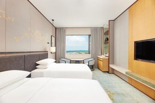 揚州市にあるCourtyard by Marriott Yangzhouの病室にはベッド3台とテレビが備わります。