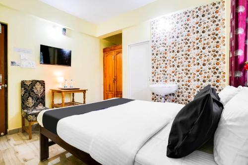 a hotel room with a bed and a chair at Hotel O Casa De Elevterio in Goa