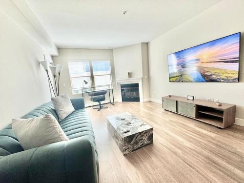 a living room with a blue couch and a table at Cozy Large 1 Bedroom Condo by UCLA in Los Angeles