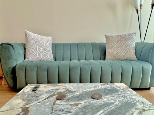 a blue couch in a living room with a table at Cozy Large 1 Bedroom Condo by UCLA in Los Angeles