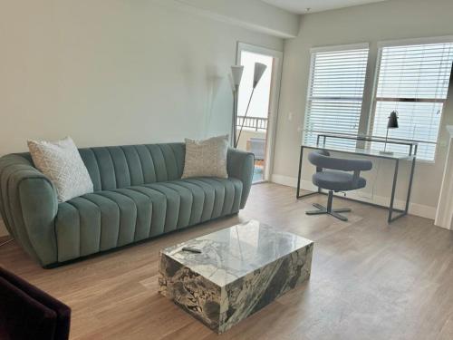 a living room with a green couch and a table at Cozy Large 1 Bedroom Condo by UCLA in Los Angeles