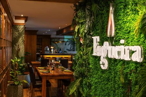 a restaurant with a green wall with a restaurant sign on it at Delta Hotels by Marriott Jumeirah Beach, Dubai in Dubai