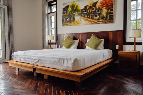 una camera da letto con un letto grande con struttura in legno di Hoi An Holiday Villa a Hoi An