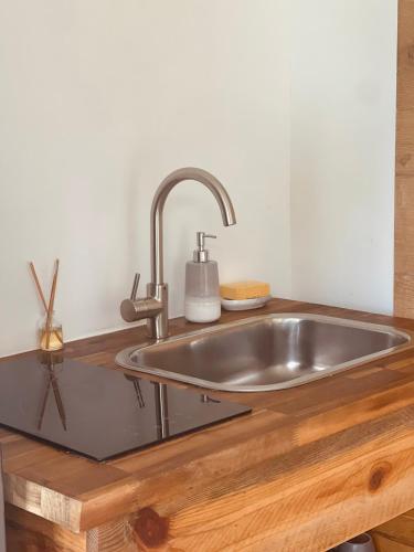 a kitchen sink with a wooden counter top at Villa Kayooli in Trois-Rivières