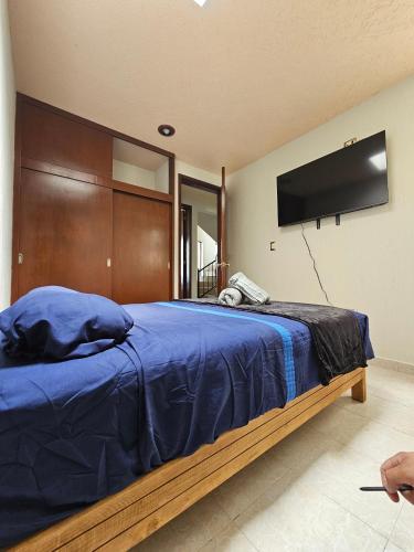 a bedroom with a bed with a tv on the wall at Casa-Oxa in Ixmiquilpan
