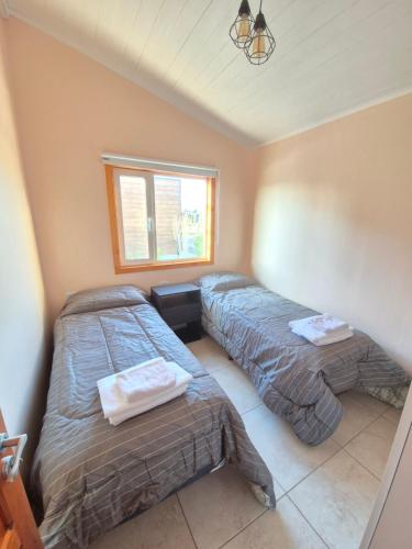 una camera da letto con due letti e una finestra di Costasueños a El Calafate