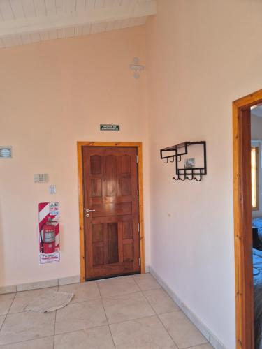 una camera con una porta in legno e un cartello sul muro di Costasueños a El Calafate
