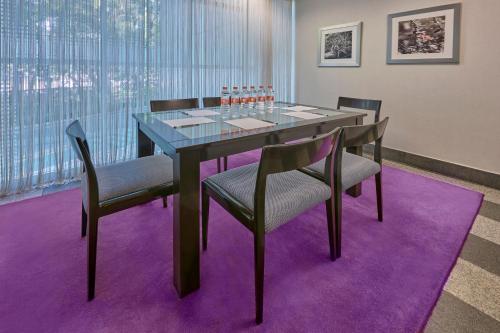 a dining room with a table and chairs on a purple rug at City Express Plus by Marriott Ciudad de México Reforma El Ángel in Mexico City