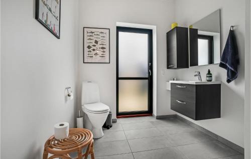 a white bathroom with a toilet and a sink at 4 Bedroom Gorgeous Home In Fur in Fur