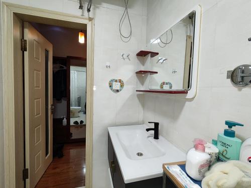 un bagno con lavandino e specchio di 博博家精品民宿 a Harbin