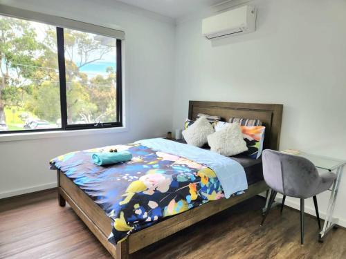 Un dormitorio con una cama y un escritorio y una ventana. en Rowville Stay - Home Away from Home, en Rowville