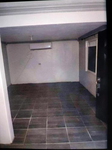 an empty garage with a tiled floor and white walls at Alojamiento en col independencia in Mexicali
