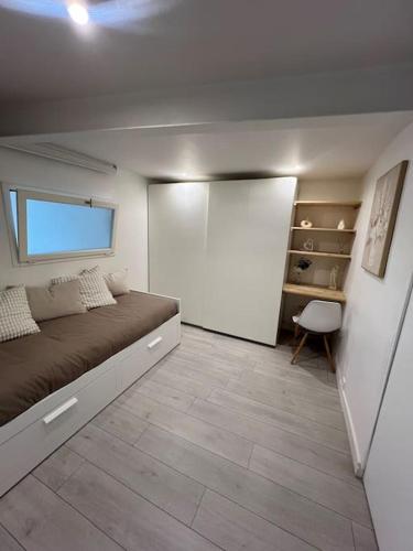 une chambre avec un lit et un mur blanc dans l'établissement Confort en centre ville à moins de 15 min d Orly, à Longjumeau