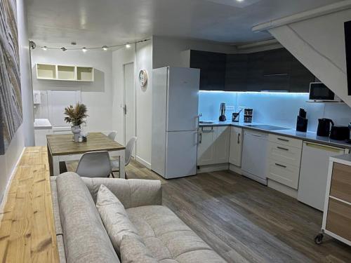 un salon avec un canapé et une table et une cuisine dans l'établissement Confort en centre ville à moins de 15 min d Orly, à Longjumeau