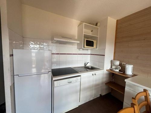 une petite cuisine avec un réfrigérateur et un évier dans l'établissement Appartement calme 3 pièces avec balcon et parking aux Angles - FR-1-593-118, aux Angles