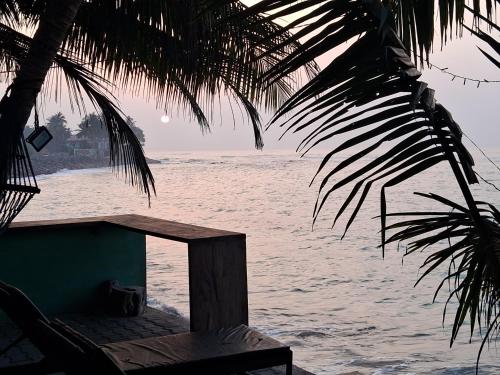 a view of the ocean from under a palm tree at Turtle Beach Talpe in Talpe