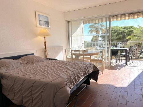 une chambre avec un lit et un balcon avec une table et des chaises dans l'établissement Studio cosy proche plage, Le Lavandou - FR-1-251-847, au Lavandou