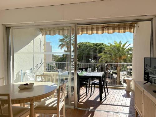 Il dispose d'une cuisine et d'une salle à manger avec un balcon et une table. dans l'établissement Studio cosy proche plage, Le Lavandou - FR-1-251-847, au Lavandou