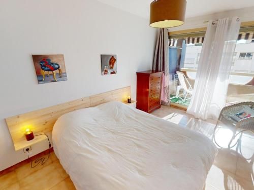 une chambre avec un lit blanc et une fenêtre dans l'établissement 2P calme avec terrasse, piscine, parking et wifi - FR-1-196-368, à Menton