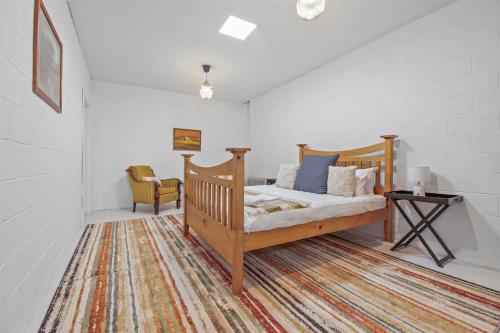 a bedroom with a wooden bed and a table at Heights of Luxury - Elite Contemporary Entertainer in Wagga Wagga