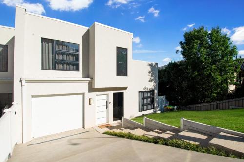 a white house with a garage at Heights of Luxury - Elite Contemporary Entertainer in Wagga Wagga