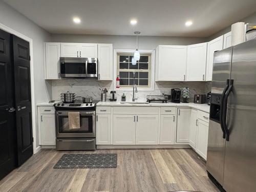 a kitchen with white cabinets and a stainless steel refrigerator at Cabin near kalahari,camelback Ski in Long Pond