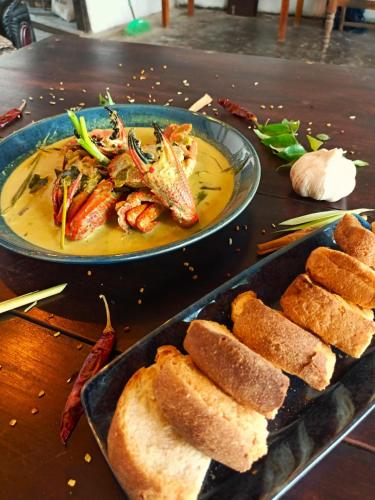 a plate of food with shrimp and bread on a table at Turtle Beach Talpe in Talpe