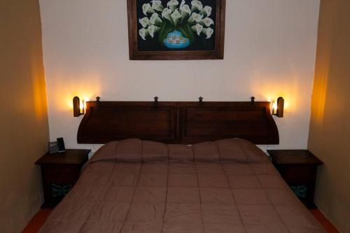 a bedroom with a bed with two night stands and a painting at Small and comfy loft near Atlixco's center in Atlixco