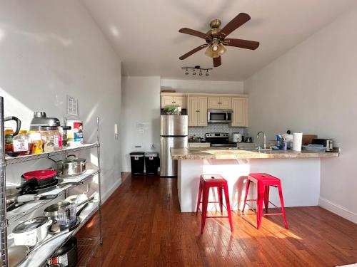 a kitchen with two red stools at a counter at Urban Luxury Hudson River Suite in New York