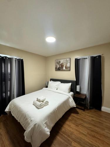 a bedroom with a large white bed with towels on it at Ferry Getaway Home! in Niagara Falls