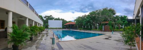 a swimming pool in the middle of a building at Nilan Zingle Resort in Puducherry