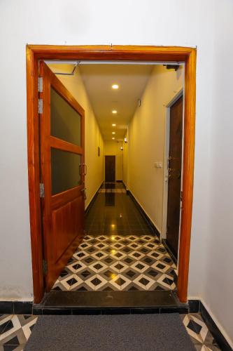 an empty hallway with a door and a tiled floor at Nilan Zingle Resort in Puducherry