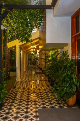 a hallway of a building with plants on the floor at Nilan Zingle Resort in Puducherry