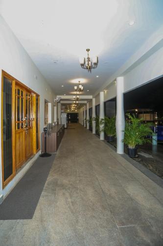 an empty hallway in a building with potted plants at Nilan Zingle Resort in Puducherry
