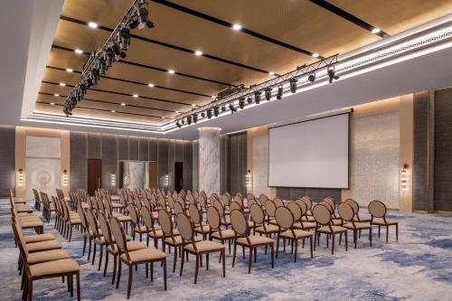 a conference room with chairs and a projection screen at The St. Regis Marsa Arabia Island, The Pearl Qatar in Doha