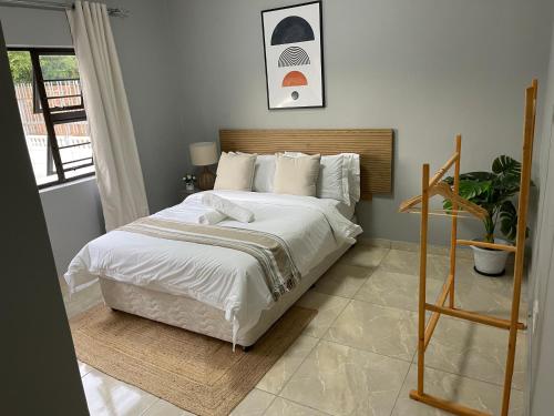 a bedroom with a large bed with white sheets and pillows at Maita Guest in Cape Town