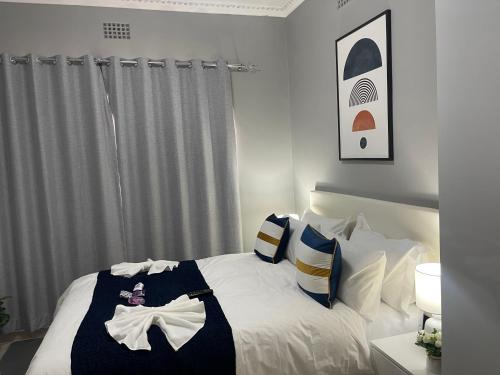 a bedroom with a bed with white sheets and pillows at Maita Guest in Cape Town